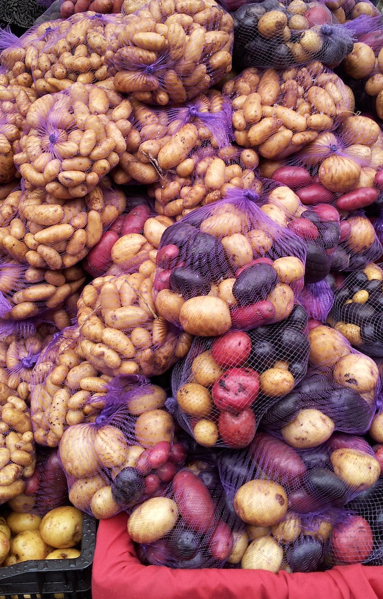 a stack of colorful potatos in bags